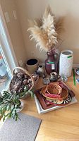 Group shot of vases, trays, basket with pinecones and plant