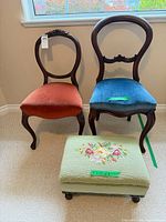 Two balloon-back chairs (rust and blue velvet) and green needlepoint ottoman
