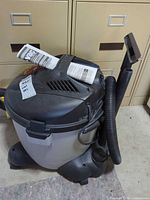 Overall view of Shop-Vac on wheeled base with hose and attachments