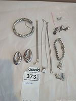 All twelve silver jewelry pieces laid out for overview