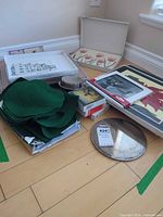 Assorted decor items including placemats, coasters, boxed prints and charger displayed on floor