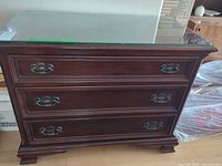 Front and top view of mahogany dresser with glass top