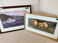 Both framed John Rusnak prints leaning against wall