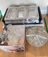 Overall view of buffet server with pans and lids, punch bowl set and boxed cups