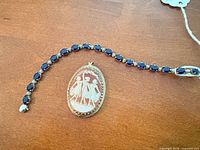 Cameo pendant beside sapphire tennis bracelet showing design, stones, and metal colour