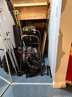 Overall view of walker frame, crutches, black bags containing PPE, wooden cane and other medical supplies