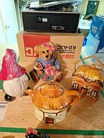 All four ceramic items grouped: teapot, cookie jar, bear figurine, gnome figurine