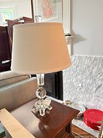 Full view of crystal glass table lamp with shade on end table