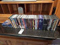 Full line-up of roughly 40 DVD cases and box sets on countertop