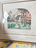 Front view showing matted town landscape print in gold frame