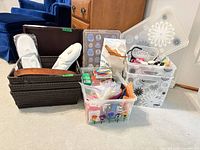 All items grouped: three synthetic wicker baskets with belts and slippers, three Curver floral bins, assorted items in clear bin