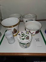 Group of five bowls and one lidded jar showing assorted motifs
