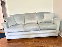 Front view of La-Z-Boy pale blue sofa showing three seat and back cushions and two pillows