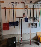 Full wall view of shovels, rakes, fork, broom
