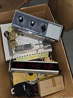 Box contents showing Hallicrafters HA-4, ON THE AIR sign, manuals, cords