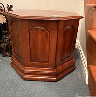 Angled view of octagonal end table showing door front, side panels, base molding