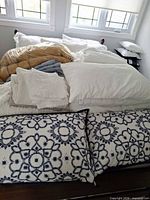 Overview of pillows, folded blankets, pillowcases and shams on bed