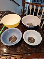 Top view of four graduated mixing bowls showing interiors and colours