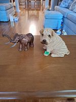 elephant and dog resin figurines on tabletop