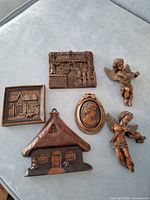 All six resin composite wall plaques arranged on surface showing designs and finishes