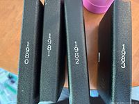 Four black Royal Canadian Mint presentation cases marked 1980, 1981, 1982, 1983