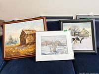 Three framed artworks grouped on sofa