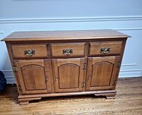 Front view showing drawers, doors, finish and hardware