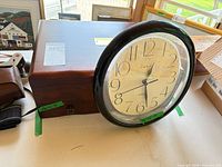 Clock resting against jewelry box showing clock face and overall box