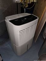 Front and side view of Whirlpool white dehumidifier showing control panel and intake grill
