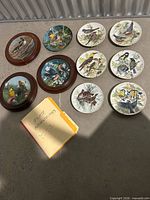 All eleven plates and authenticity folder laid out