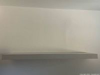 Installed white floating shelf on wall