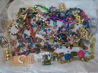 Full view of mixed beads, strands, charms and findings spread on surface