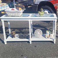 Front view of white console table with staging items on top and shelf