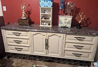 Front view of dresser showing nine drawers, marble top, and iron base