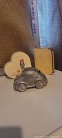 Front view of all three coin banks showing Beetle, heart, and book designs