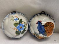 Front view of both ceramic molds showing floral and rooster designs