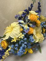 Overall view of faux floral centerpiece with mixed blue, yellow flowers