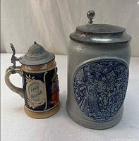 Two steins side by side showing size and design differences