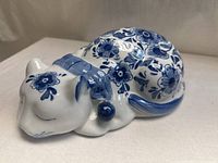 Top view of blue and white floral ceramic sleeping cat figurine