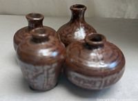 Four small brown stoneware vases grouped, front view