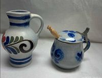 Both stoneware pieces side by side showing shape, glaze, and decoration