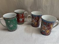 Four mugs grouped together showing both Takahashi and Smithsonian designs