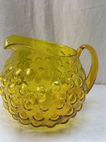 Full side view of amber hobnail pitcher