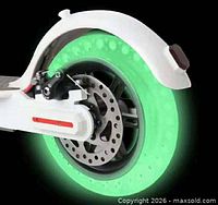 Tire installed on scooter wheel glowing green in dark