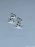 Front view of both earrings showing circular design and diagonal groove