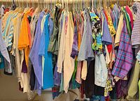 Full clothing rack densely packed with assorted womens tops of various colors and patterns