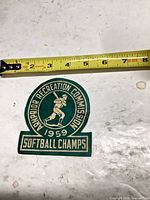 Front of green and cream patch with tape measure showing width