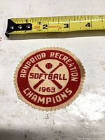 Front of embroidered patch showing text, graphics, ruler indicating size