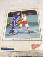 Front panel showing colour action photo of Alex Delvecchio with caption and logo