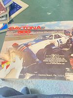 Front cover of 1979 Daytona 500 program showing car in pit stop with torn lower left corner